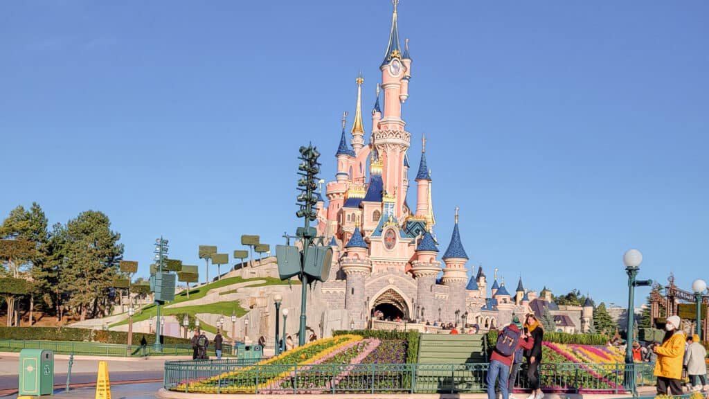 Vue du château de Disneyland Paris sous un ciel bleu, symbole de magie et de bien-être dès l’arrivée au parc.